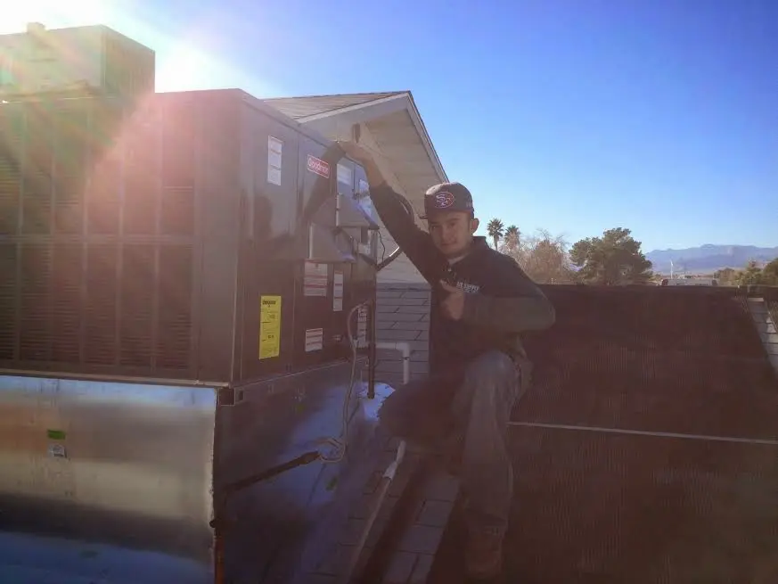 HVAC technician performing Boiler Repair on a rooftop unit in North Dansville